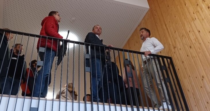 Architekt Martin Pöllot (rechts) führt das Publikum, darunter auch Winkelhaids Bürgermeister Michael Schmidt (Mitte), durch die Musikschule Lauf und erläutert die Holzstapelbauweise.