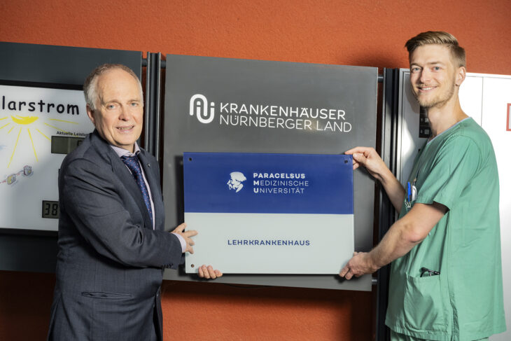 PMU-Vizerektor Prof. Dr. Theodor Fischlein (links) und Assistenzarzt Dr. Maximilian Haupt mit dem
neuen Lehrkrankenhaus-Schild vor dem Krankenhaus Lauf.