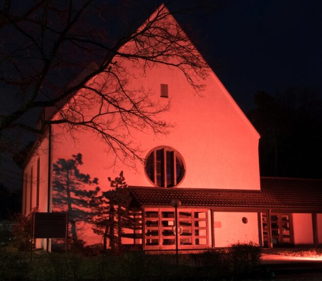 Auch die katholische Pfarrei in Winkelhaid wird in rotes Licht getaucht.