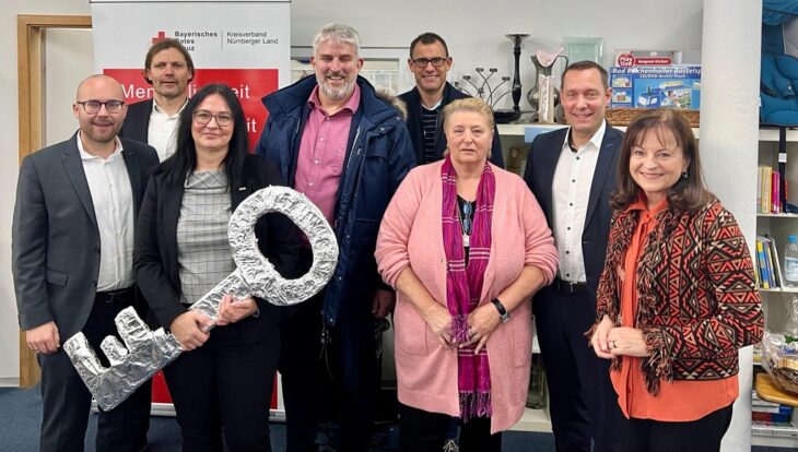 Das Bild zeigt die neue „Bereichsleiterin Läden“ des BRK Nürnberger Land, Silke Weidinger (3. v. l.) mit ihrer Vorgängerin Uschi Hofmann (3. v. r.), umrahmt von Ehrengästen bei der Einweihung des neuen Rotkreuzladens.