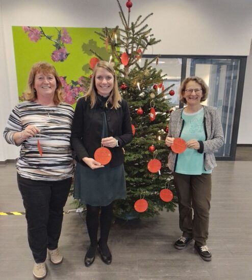 Mechthild Scholz (Leitung Mehrgenerationenhaus), Daniela Taubmann (Leitung Sparkasse Röthenbach) und Michaela Sachse (Mitarbeiterin Mehrgenerationenhaus, von rechts) vor dem Wunschbaum.