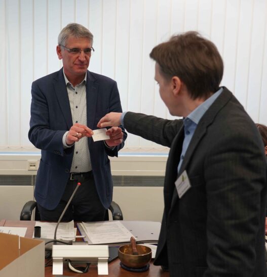 Stellvertretender Landrat Helmut Brückner (links) präsentiert Werner Hendelmeier von der Kreistagsgeschäftsstelle das Ergebnis des Losverfahrens.
