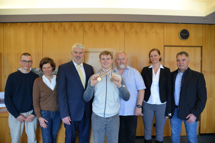 Till Hugenroth gemeinsam mit Bürgermeister Lang sowie mit seinem Bruder Ben Hugenroth (links), seiner Mutter Dagmar Hugenroth (2. v.l.), Dieter Klemens (Präsident Skiverband Frankenjura, 3. v.r.), Alexandra Fischer (Vizepräsidentin Skiverband Frankenjura, 2. v.r.) und Gerald Rutz (1. Vorsitzender DAV Lauf).