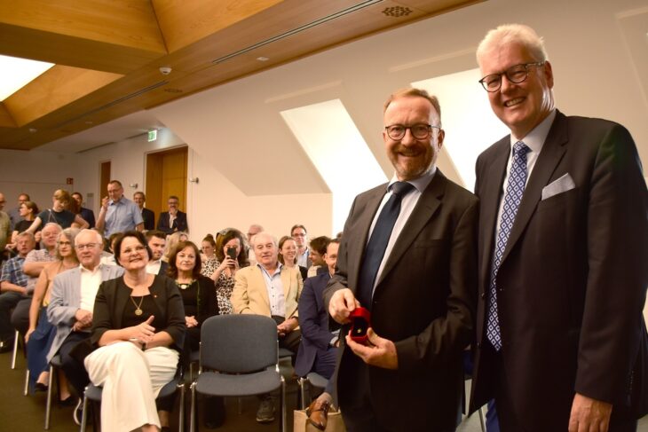 Matthias Everding (rechts), der Vorstandsvorsitzende der Sparkasse Nürnberg, verlieh Otfried Bürger zum Abschied die Sparkassen-Ehrennadel.