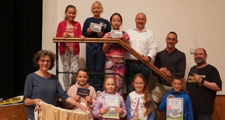 Büchereileiterin Antje Fritzsche, Bürgermeister Jörg Kotzur, Hauptamtsleiter Florian Schmidt und Detektiv Alexander Schrumpf inmitten der Gewinnerkinder des Sommerferien-Leseclubs 2024.