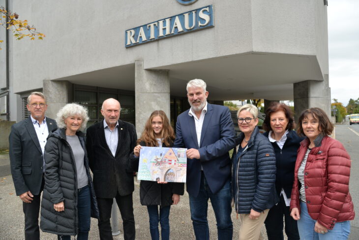 Bürgermeister Thomas Lang (Bildmitte), die Schülerin Leni Mayer und Vertreter der Laufer Lions das Motiv des neuen Lions-Adventskalenders.