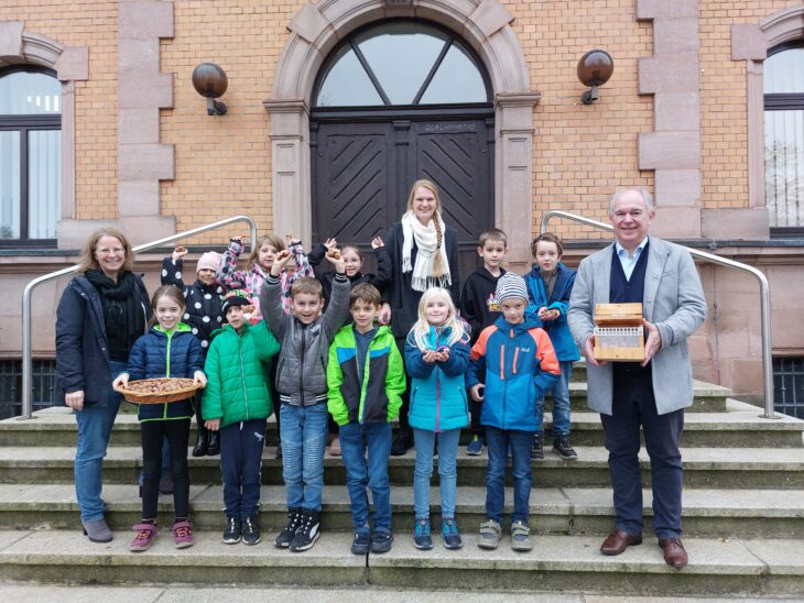 Tanja Hofmann (links), Katharina Pöhler (Mitte) und Bürgermeister Klaus Hacker (rechts) umringt von Grundschülern der Klasse 1/2a der Grundschule am Forstersberg.
