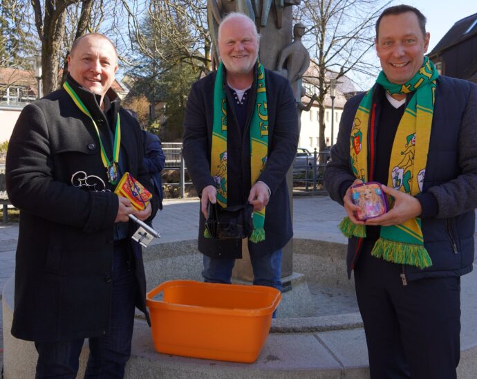 Erster Bürgermeister Jörg Kotzur (links) und Landrat Armin Kroder (rechts) zusammen mit Andreas Grelka, 1. Vorsitzender der Faschingsgesellschaft Feucht-fröhlich, beim Geldbeutelwaschen am Brunnen in Feucht.
