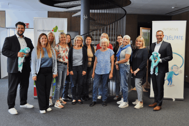 Fröhliche Gesichter beim Abschluss- und Dankestreffen der Kritzelpatinnen. Landratsamt-Abteilungsleiter Dr. Nico Böhme (l.), Stephanie Heißmann vom WinWin Freiwilligenzentrum (2. v. l.), Sonja Lambrecht vom Schreibmotorikinstitut (4. v.r.), Landrat Armin Kroder (r.) und ein Teil der engagierten Kritzelpatinnen.