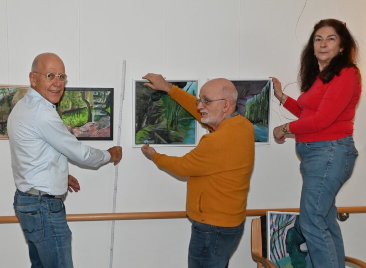 Francoise Werner, Dr. Rüdiger Kretschmann und Jürgen Pfaff beim Aufhängen der unterschiedlichen Kunstwerke (von rechts).