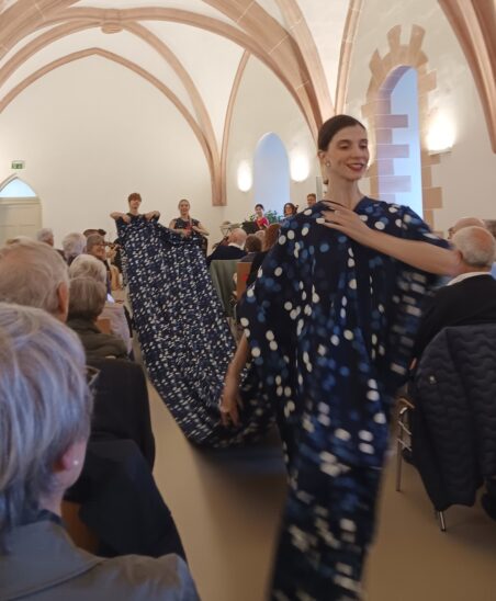 Eine Tänzerin des Nationaltheaters führt eine meterlange Schleppe aus Blaudruck-Stoffen vor.