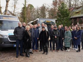 Landrat Armin Kroder (6.v.l.), die AG ÖPNV und Vertreter der beteiligten Busunternehmen mit zwei der neuen Fahrzeuge.