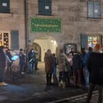 Auf dem Foto sieht man unter anderem den Gemeinderat bei der Eröffnung des sogenannten Adventsfensters an einer Hausmauer.