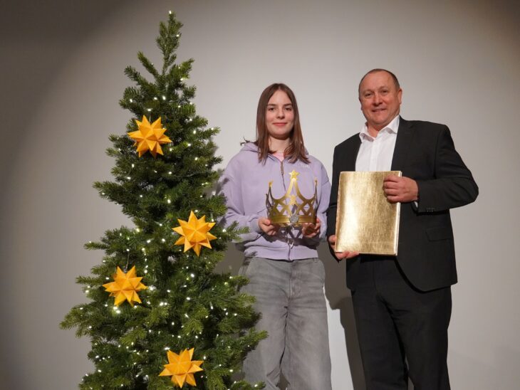 Bürgermeister Jörg Kotzur überreicht dem diesjährigen Christkind von Feucht, Johanna Bauer, die Christkind-Krone und das Goldene Buch.