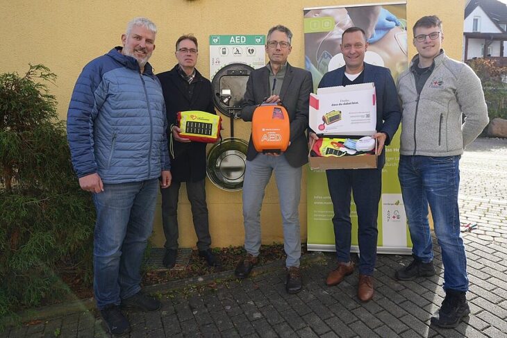 Erster Bürgermeister Thomas Lang, Pfarrer Stefan Alexander (Katholische Kirchengemeinde St. Otto), Dr. Michael Groß (Geschäftsführer der Caritas Nürnberger Land), Landrat Armin Kroder und Tobias Buchholz (lokaler Ansprechpartner des Projektes) freuen sich über den neuen Defibrillator (von links).