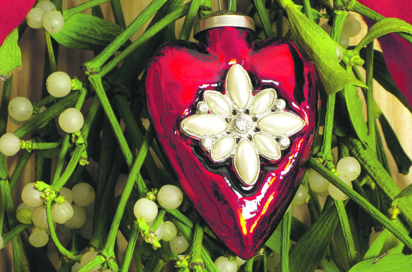 Auf dem Foto sieht man einen Mistelzweig mit rotem Dekoherz