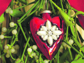 Auf dem Foto sieht man einen Mistelzweig mit rotem Dekoherz