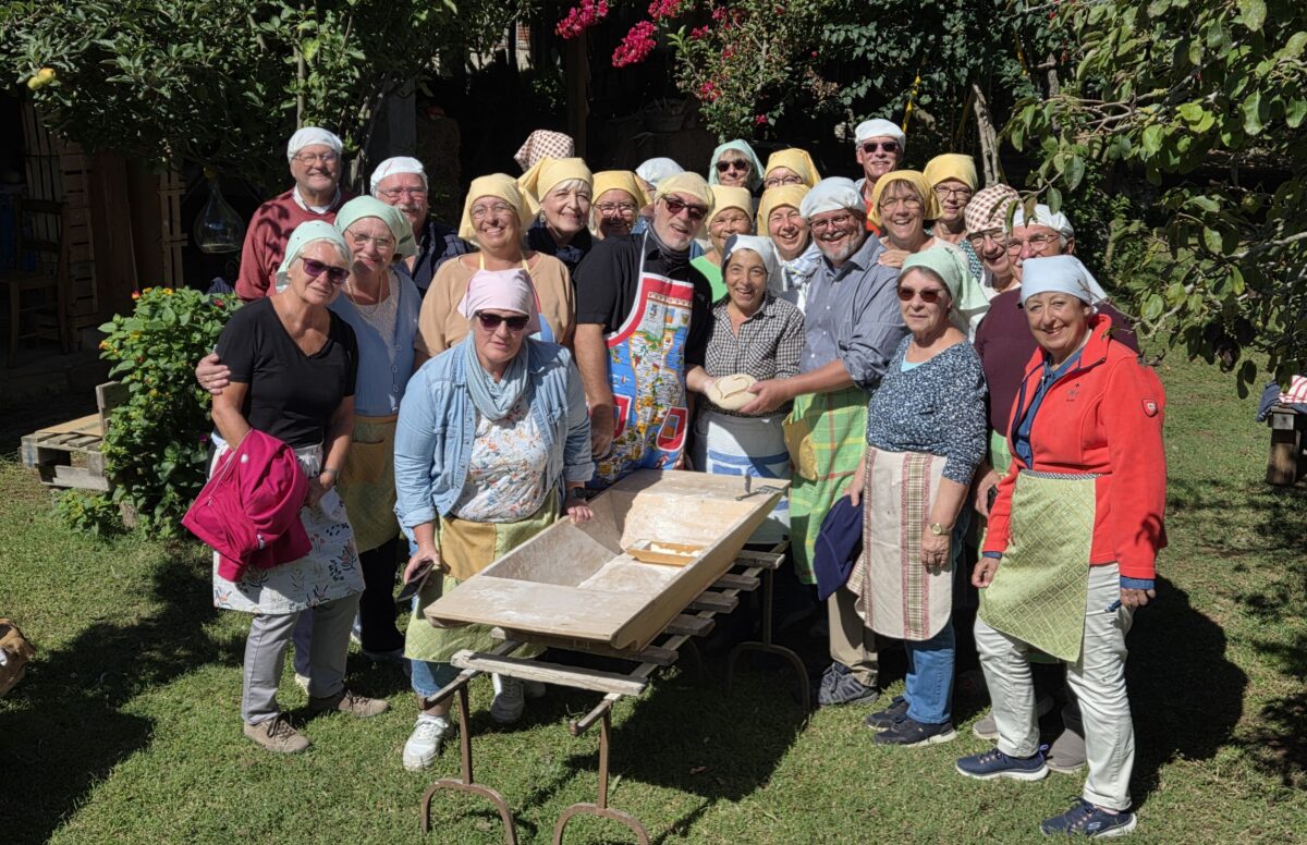 Auf dem Foto sieht man eine Gruppe von etwa 25 Menschen bei einem Brotbackkurs.