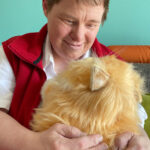 Seniorin Heike Neumann zeigt erste Anzeichen von Demenz. Beim Kuscheln mit KI-Katze Minka hebt sich ihr Gemütszustand merklich.