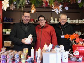Drei Männer in einem Stand auf dem Christkindlesmarkt