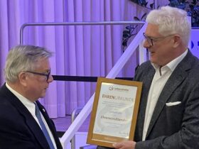 Jürgen Six (rechts) überreicht seinem Vorgänger Gerhard John die Urkunde, mit der er zum Ehrenvorsitzenden der Lebenshilfe wird.