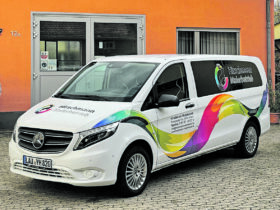 Auf dem Foto sieht man ein Firmenauto vor einem Gebäude