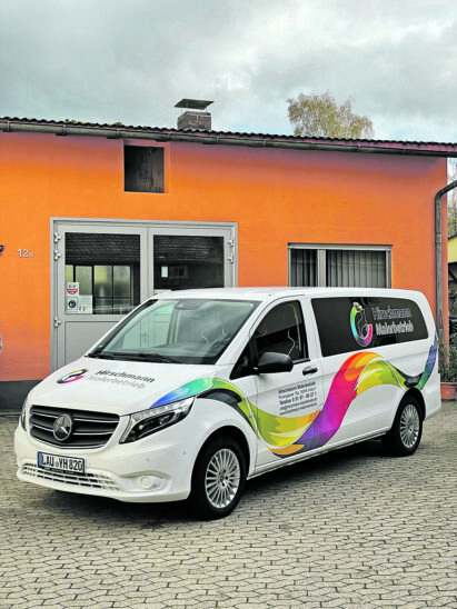 Auf dem Foto sieht man ein Firmenauto vor einem Gebäude