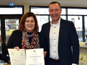 Landrat Armin Kroder überreicht Gabriele Reiser bei ihrer Verabschiedung die Entlassurkunde.