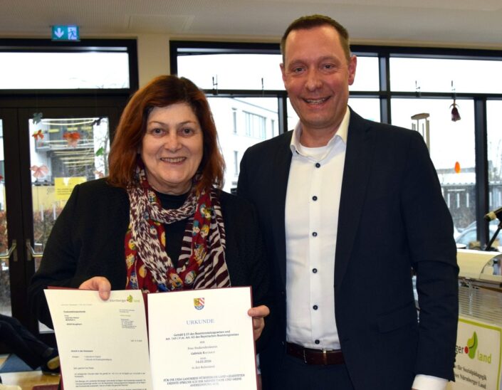 Landrat Armin Kroder überreicht Gabriele Reiser bei ihrer Verabschiedung die Entlassurkunde.