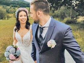 Die Braut mit elegantem Strauß und blumigem Reif im Haar, der Bräutigam mit kleinem Anstecksträußchen. Foto: Magical Hydrangea/Anna Haslauer