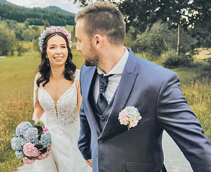 Die Braut mit elegantem Strauß und blumigem Reif im Haar, der Bräutigam mit kleinem Anstecksträußchen. Foto: Magical Hydrangea/Anna Haslauer