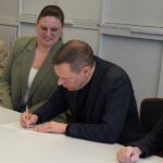 Landrat Armin Kroder unterzeichnet die Bewerbung unter den Augen von (von links) Schulamtsleiter Joachim Schnabel, Projektverantwortlicher Elisa Bräutigam und Landtagsabgeordnetem Norbert Dünkel.