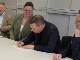 Landrat Armin Kroder unterzeichnet die Bewerbung unter den Augen von (von links) Schulamtsleiter Joachim Schnabel, Projektverantwortlicher Elisa Bräutigam und Landtagsabgeordnetem Norbert Dünkel.