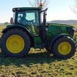 Ein Landwirt beim Walzen einer Grünfläche.