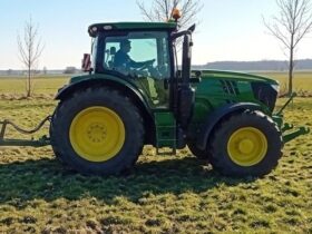 Ein Landwirt beim Walzen einer Grünfläche.