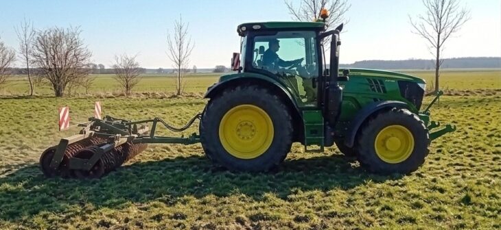 Ein Landwirt beim Walzen einer Grünfläche.