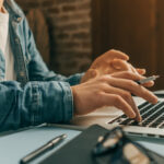 Eine Person arbeitet am Laptop von Zuhause aus.