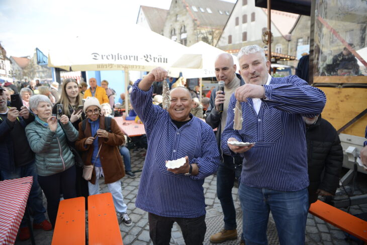 Bürgermeister Thomas Lang (rechts) und Fischhändler Thorsten Niebuhr probieren Matjes, dahinter Moderator Martin Czernan.