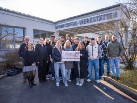 Vor dem Eingang der Werkstätten übergaben elf Auszubildende gemeinsam mit ihren Ausbildern eine Spende für die Werkstattarbeit der Lebenshilfe.