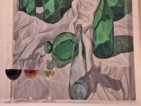Das Bild zeigt drei Weingläser vor einem Werk aus der Sammlung Appelt. Das Gemälde ohne Titel aus dem Jahr 1991 stammt von Christoph Klein, der an der Kunstakademie im Wenzelschloss studierte.