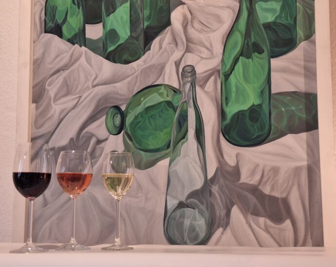 Das Bild zeigt drei Weingläser vor einem Werk aus der Sammlung Appelt. Das Gemälde ohne Titel aus dem Jahr 1991 stammt von Christoph Klein, der an der Kunstakademie im Wenzelschloss studierte.