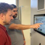 Hendrik Nijhuis (links) und Andreas Mark von der Hewa vor dem Steuermodul des Wärmenetzes Raiffeisenstraße Süd. In einem Pilotprojekt versuchen sie gemeinsam mit der Nürnberger Firma Diehl Metering die Energiewende vor Ort durch KI effizienter und damit wirtschaftlicher zu machen.