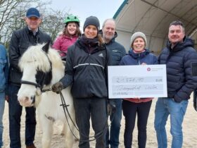 Große Freude bei Klientin Sophia auf dem Pferd Rupert, der Reittherapeutin Tina Kokott (4. von links) und bei Sandra Uhl (3. von rechts), der Leiterin des Therapiehofs Leila, bei der Spendenübergabe durch Vertreter der Rummelsberger Diakonie und der Lotte Schopper Stiftung.