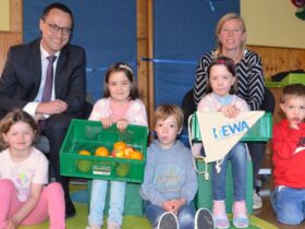 Hewa-Geschäftsführer Harald Kiesl mit Daniela Schindler, Leiterin der Kneipp-Kita „Altstadtzwerge“, und einigen der dortigen Kinder, die jetzt wieder in jeder Schulwoche ihre geliebte gesunde Obstkiste vom Hutzelhof geliefert bekommen.