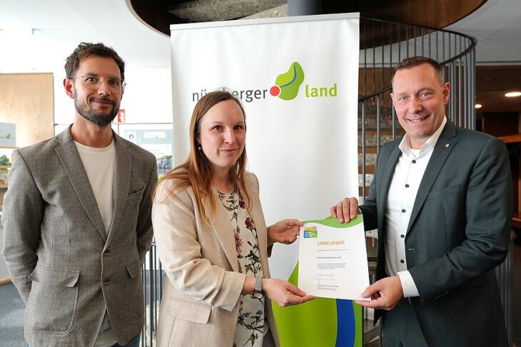 Landrat Armin Kroder (rechts) übergibt die Umweltpakt-Urkunde an Stefanie Bezold und Oliver Fürsattel (beide Abteilung Umweltschutz und Arbeitssicherheit Excella GmbH & Co. KG).