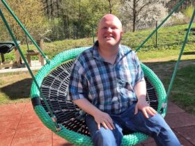 Hannes freut sich über die neue Schaukel im Garten des Wohnbereichs für Menschen im Autismus-Spektrum der Rummelsberger Diakonie in Hersbruck.