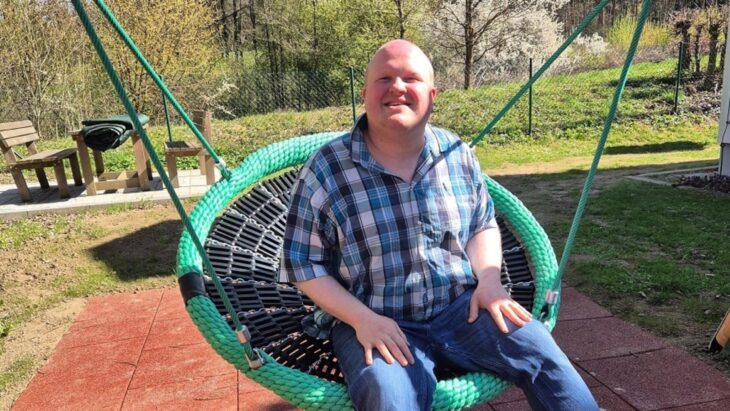 Hannes freut sich über die neue Schaukel im Garten des Wohnbereichs für Menschen im Autismus-Spektrum der Rummelsberger Diakonie in Hersbruck.