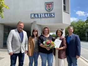 Anja Roth (Bildmitte) gemeinsam mit (von links) Carsten Pillich (Personalrat), Anna Doms (Sachgebietsleitung Einwohner- und Passamt), der zweiten Bürgermeisterin Erika Vogel sowie Dr. Jan Sommerer aus der Abteilung Interner Service.