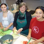 Gemeinsam mit den Ehrenamtlichen bereiten die Schülerinnen und Schüler die Pausenbrote vor.