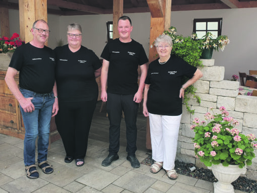 Zwei Frauen und zwei Männer im Außenbereich eines Restaurants.